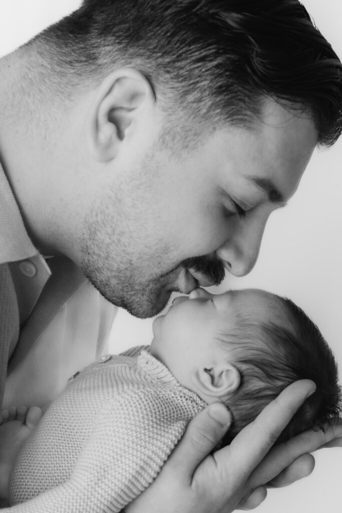 new dad kissing the nose of baby boy