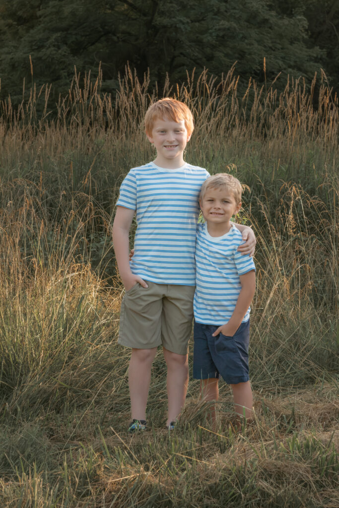 brothers posing for picture outdoors at sunset