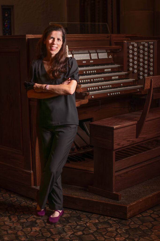 organist posing with organ in church