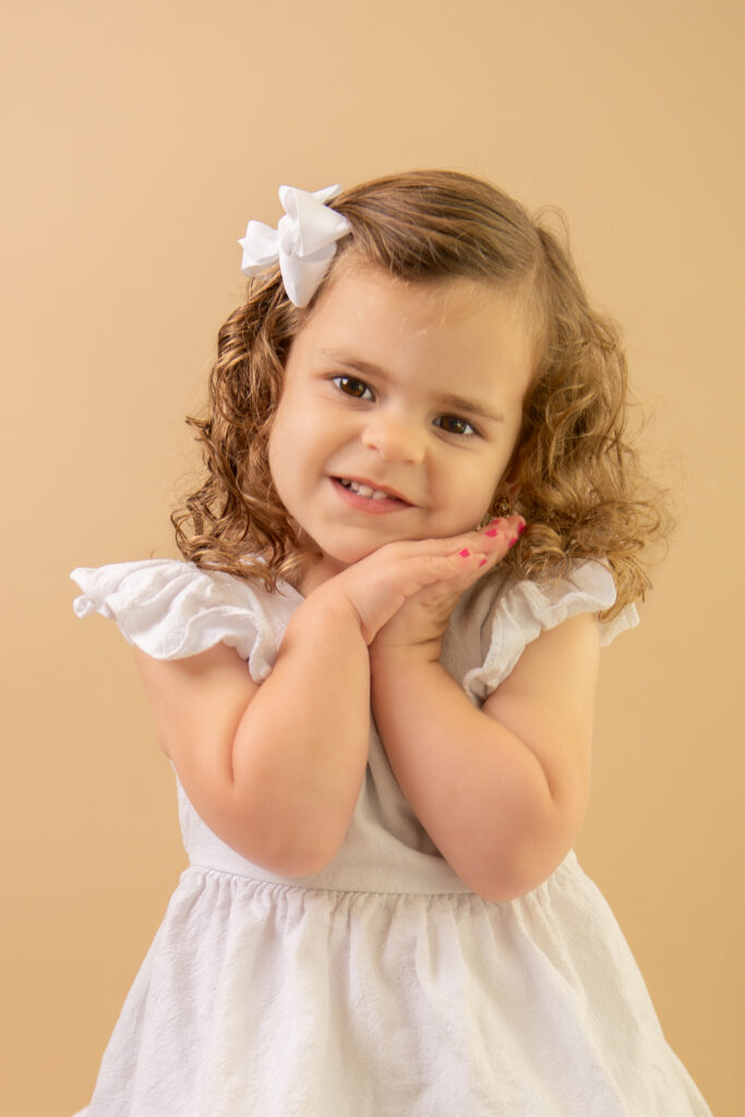 toddler girl hands clasped under cheek smiling pageant photography pictures